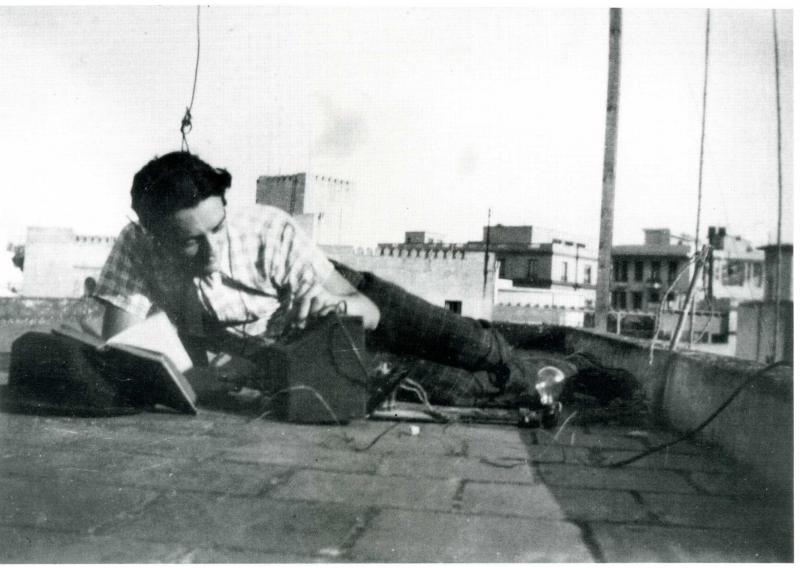 Dan Efrat penché sur une radio qu'il a fabriquée et écoute des émissions de la BBC en violation des lois d'occupation allemandes. Tunis, 1942